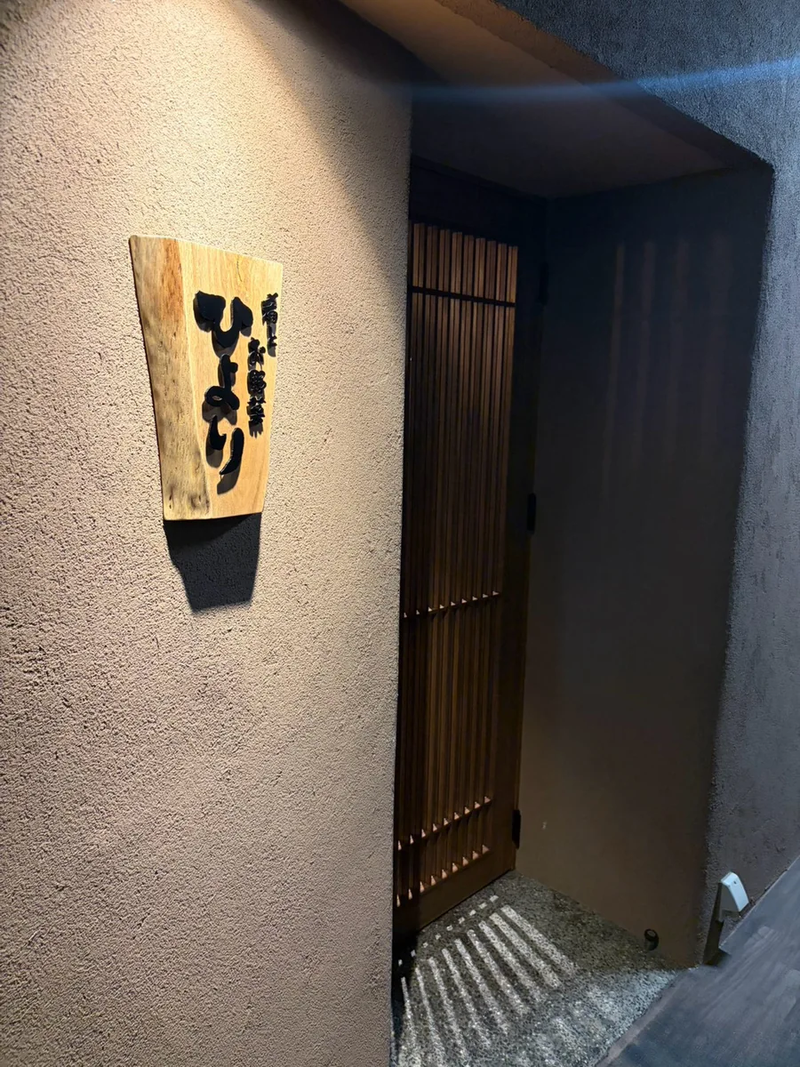 木の看板と格子戸が目印のひよりの入口